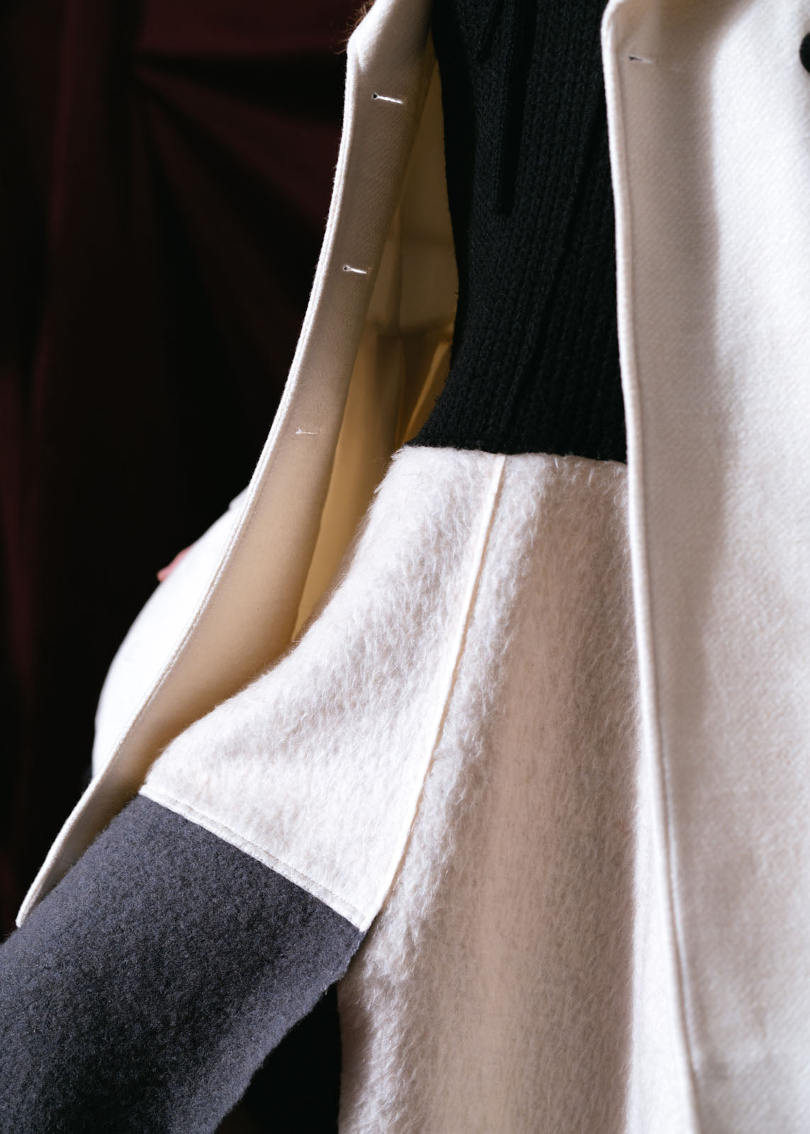 abrigo blanco de lana con olan negro en la parte jnferior, botones forrados caida tipo A coleccion otoño invierno